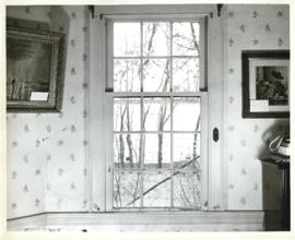 Photograph of a window in the Simeon Perkins house before its restoration, framed by art pieces o...