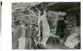 Photograph of Thomas Head Raddall, Brent Smith, and Hector Dunlap at an Eagle Lake cabin posed be...