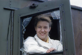 Photograph of Barbara Hinds looking through a window in Frobisher Bay, Northwest Territories