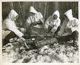 Photograph of four unidentified soldiers cooking during winter infantry training at Debert