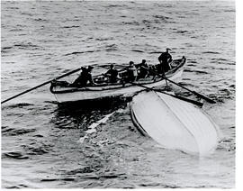Photograph of crew members from the Mackay-Bennet examining a lifeboat from the Titanic at sea