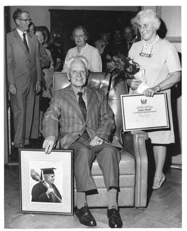 Photograph of James Stoker and Mrs. Stoker holding a framed photograph and certificate