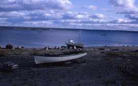 Photograph of several small boats on the shore or on the water in northern Quebec