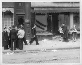 Photograph of serviceman and civilians walking past looted shops on Barrington Street in the afte...