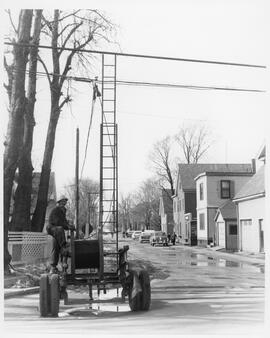 Photograph of an unidentified Island Telephone Company employee working on the lines