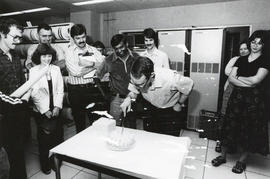 Photograph of a cake being cut during a party in the Dalhousie Computer Centre