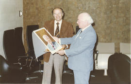 Photograph of Doug Eisner presenting a painting to Henry Hicks