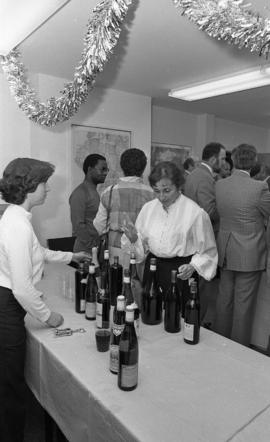 Photograph of two people with wine bottles at the opening of the Ocean Studies house