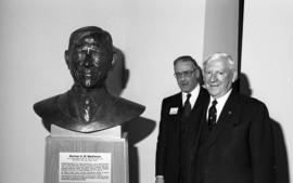 Photograph of Norman A. M. MacKenzie with a bust of himself and an unidentified man