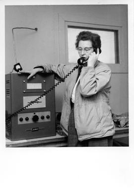 Photograph of an unidentified woman talking on a telephone