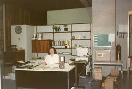 Photograph of a staff member sitting behind the circulation desk at the Killam Memorial Library