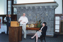 Photograph of Sylvia Fullerton listening to a guest speak at her retirement party