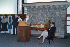 Photograph of Sylvia Fullerton listening to a guest speaking at her retirement party
