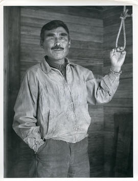 Photograph of a man with one eye ringing the bell at an Anglican church