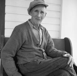 Photograph of an elderly man sitting on a bench in Dawson City, Yukon