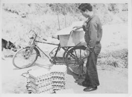 Fundraising postcard showing a patient at a leprosy clinic transporting supplies by bicycle