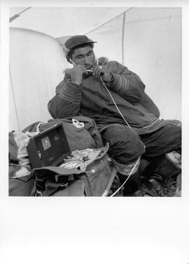 Photograph of an unidentified man with headphones and a tape recorder