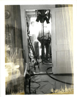 Photograph of a T.V. crew setting up equipment in Thomas Head Raddall's den