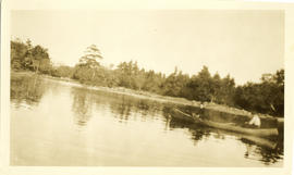 Photograph of two men in a canoe on still water