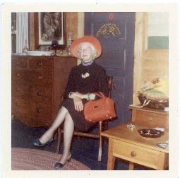 Photograph of a woman sitting in a chair, dressed for an occasion