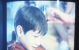 Photograph of a child on a television screen