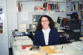 Photograph of Susan Harris, Head of the Bindery Unit, at her desk in the Technical Services Depar...
