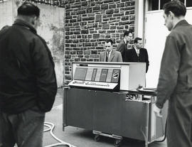 Photograph of men standing around computer equipment outside the Sir James Dunn Science Building