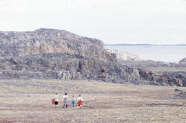 Photograph of four people walking on the tundra in Cape Dorset, Northwest Territories