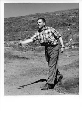 Photograph of an unidentified man throwing something