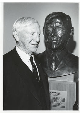 Photograph of Norman A. M. MacKenzie with a bust of himself