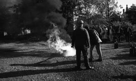 Photograph of an unidentified person putting out a fire with a fire extinguisher
