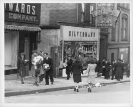 Photograph of looters carrying shoe boxes up Blower's Street past Silverman's and Edwards Fur Com...