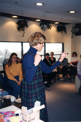 Photograph of Barbara Nielsen opening gifts in the Killam Memorial Library staff lounge