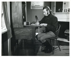 Photograph of actor David Murray portraying Simeon Perkins in period costume writing at his desk ...