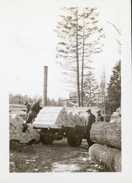 Photograph of four unidentified people loading lumber at Mount Uniacke, Hants County