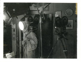 Photograph of a T.V. crewman with two cameras and lighting equipment in Thomas Head Raddall's den