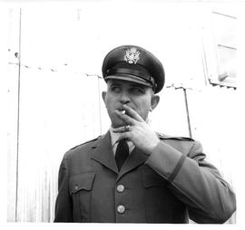 Photograph of an unidentified man wearing a uniform and smoking a cigarette