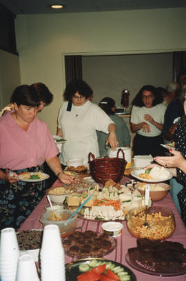 Photograph of Janet MacDonald, Joan Chiasson and Susan Harris at the buffet table during a group ...