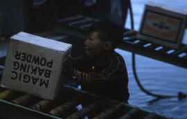 Photograph of a boy moving a box in Frobisher Bay, Northwest Territories