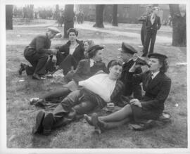 Photograph of servicemen and women drinking beer in a park on VE-Day in Halifax
