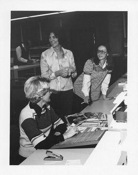 Photograph of three unidentified people in the Killam Library