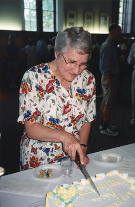 Photograph of Patricia Lutley cutting a cake at her retirement party