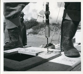 Photograph of a man using a drill while refitting the "Joan Ryan"