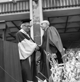 Photograph of an unidentified person shaking hands with Henry Hicks