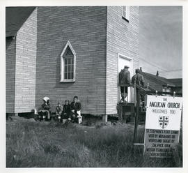Photograph of several people waiting outside of the Anglican church in Fort Chimo, Quebec