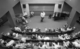 Photograph of an unidentified person giving a lecture to a music class