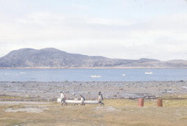 Photograph of several people carrying a canoe in Cape Dorset, Northwest Territories