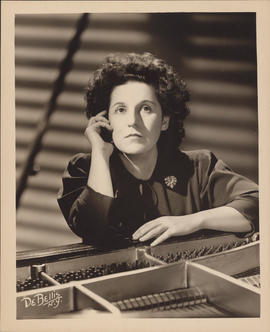 Publicity photograph of Ellen Ballon sitting at a piano