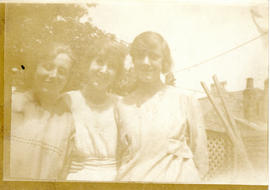 Photograph of three young women posing on a lawn