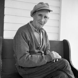 Photograph of an elderly man sitting on a bench in Dawson City, Yukon